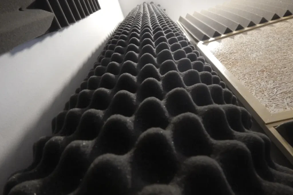 Vertical view of egg crate-shaped acoustic foam panels on a wall.