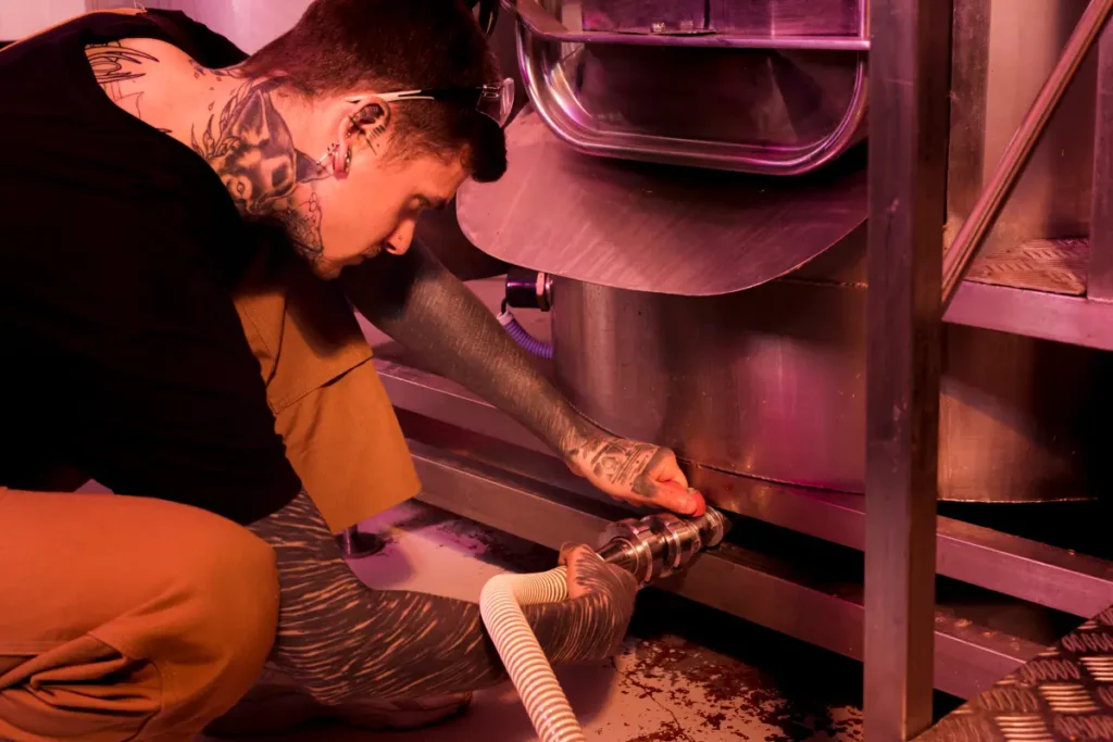 Technician repairing a steam generator in a sauna system.
