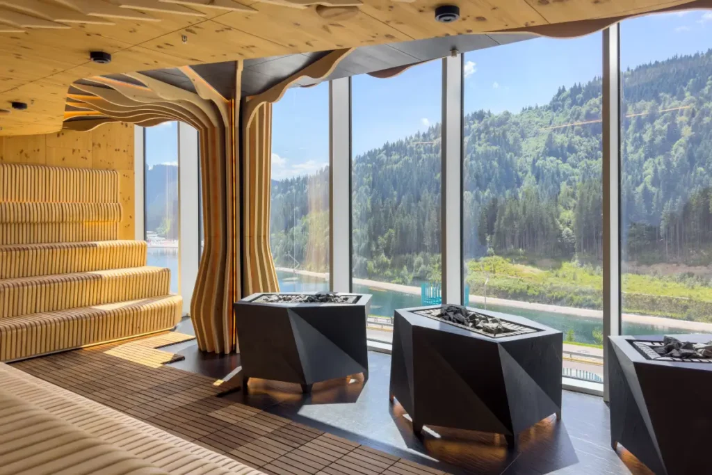 Modern sauna with wooden walls, stone heaters, and panoramic views