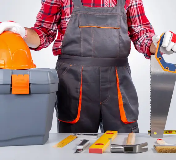 Worker holding tools and helmet, ready for sauna installation
