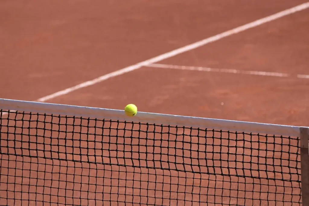 Tennis ball above net on paddle court