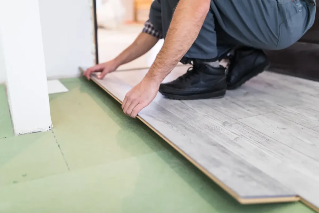 Person adjusting SPC plank for precise flooring installation.