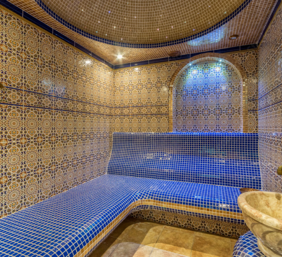 Luxurious steam room with intricate blue tiles and ambient lighting.