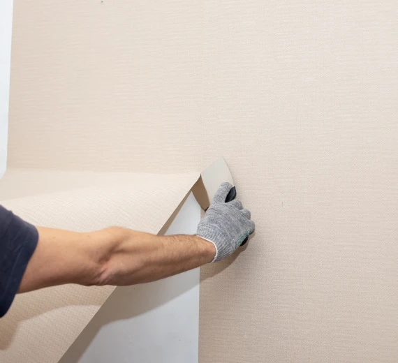 Smoothing wallpaper with scraper tool hand
