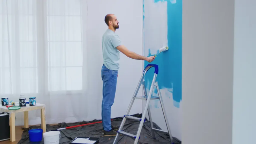 Person painting interior wall with blue