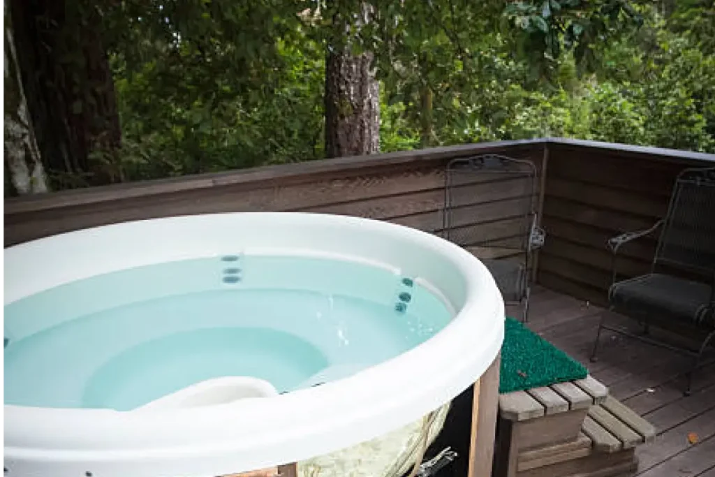 Outdoor Jacuzzi tub with a scenic view of surrounding greenery.