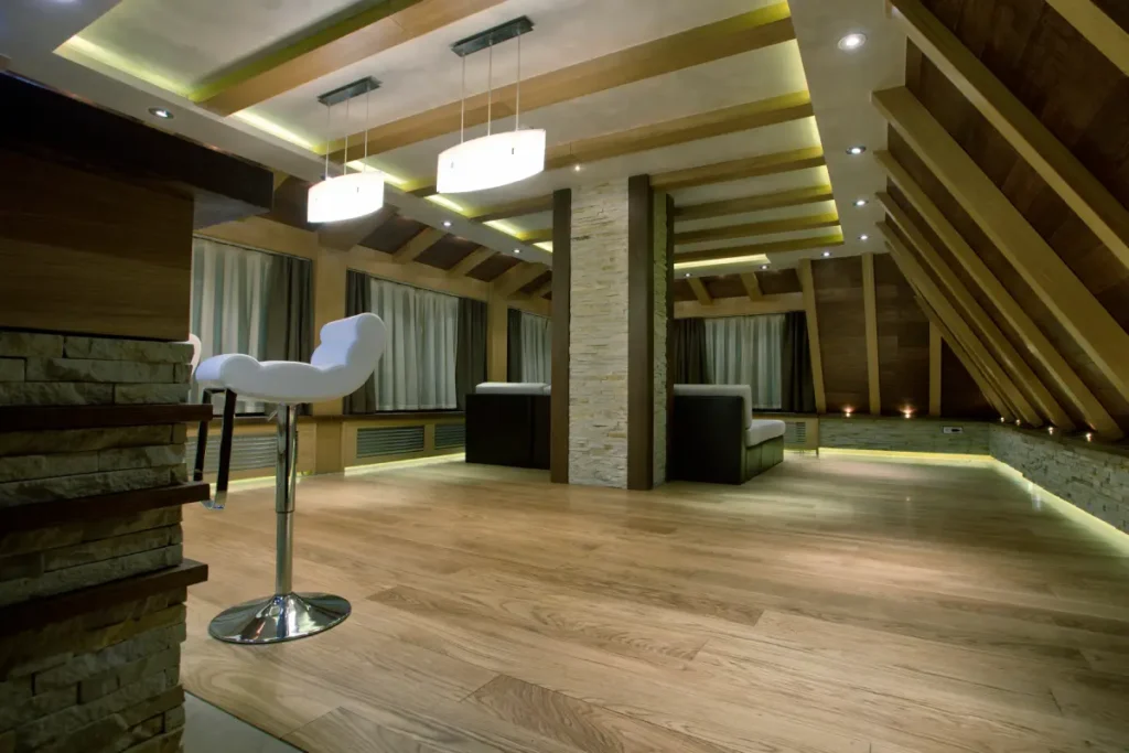 Modern attic space with wooden flooring and contemporary lighting.